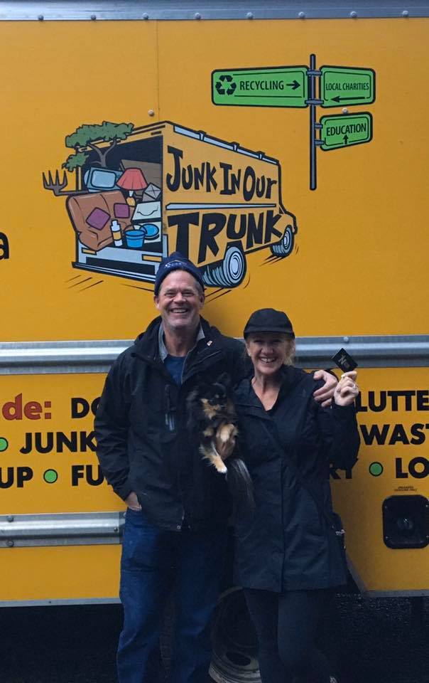 Family with their dog beside the Junk In Our Trunk truck featuring the recycling & charities signage