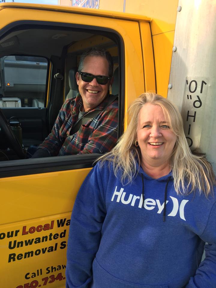 Shawn smiling from the cab of the truck with a returning customer