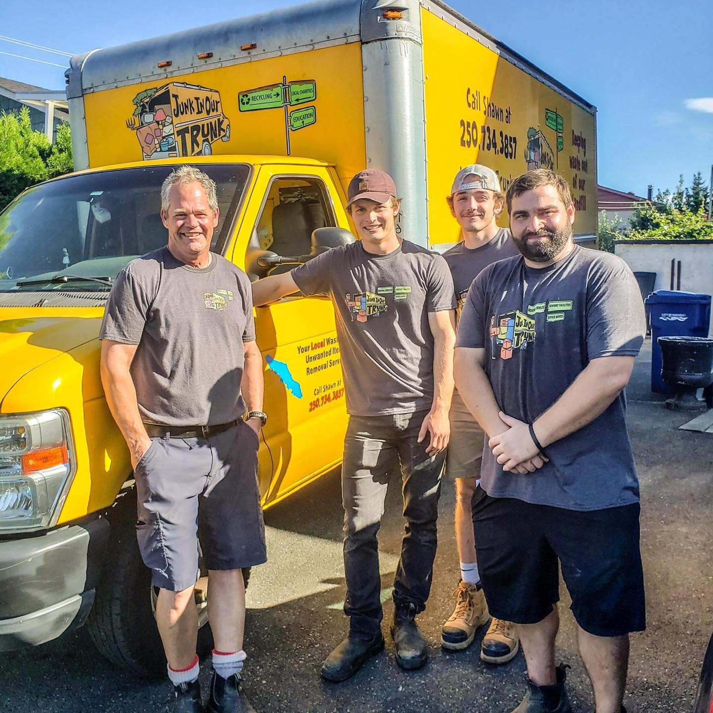 Shawn and the Junk In Our Trunk moving crew in front of their yellow truck in Nanaimo